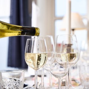 Hvidvin hældes op i glas